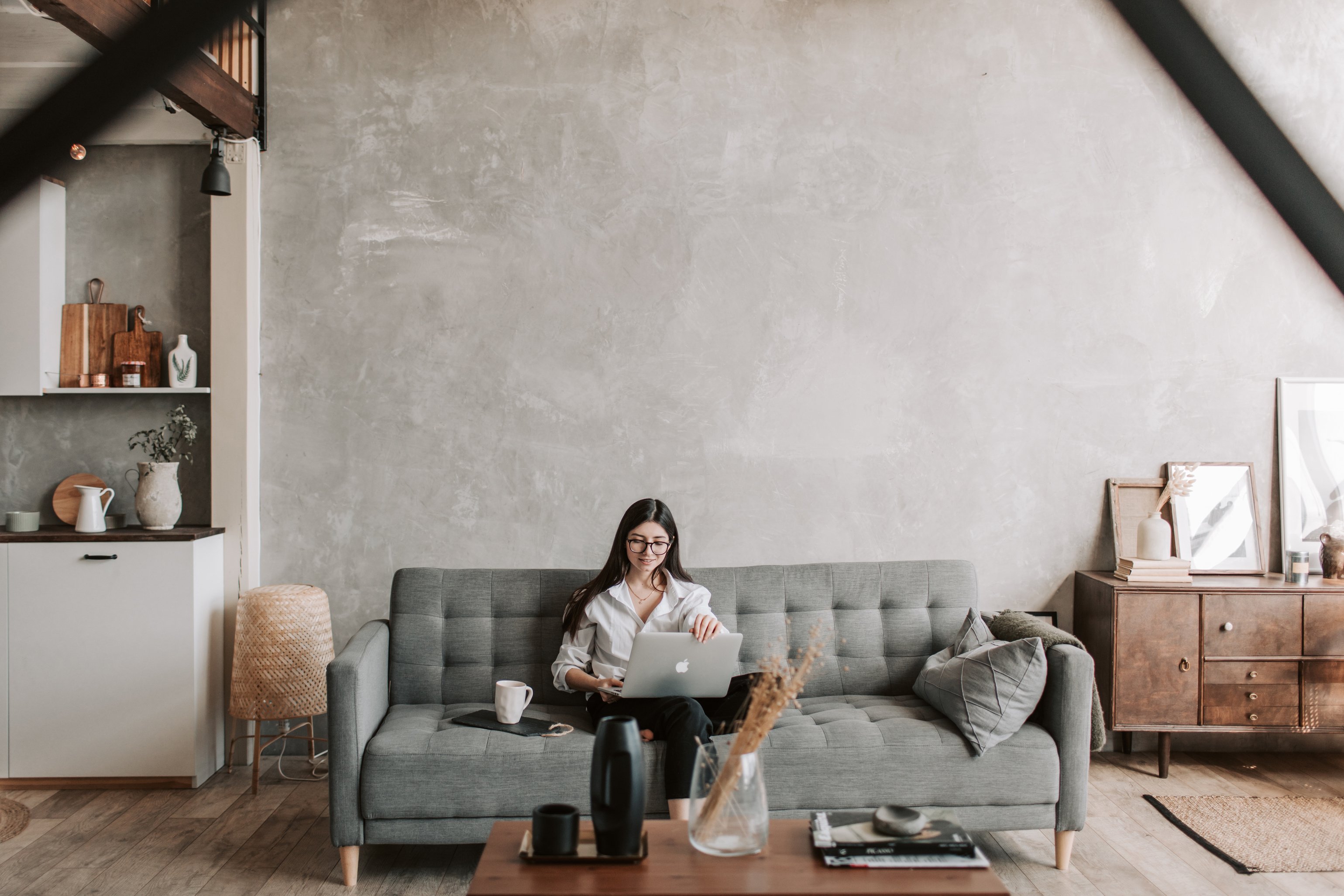 Cheerful freelancer working on laptop in loft style apartment